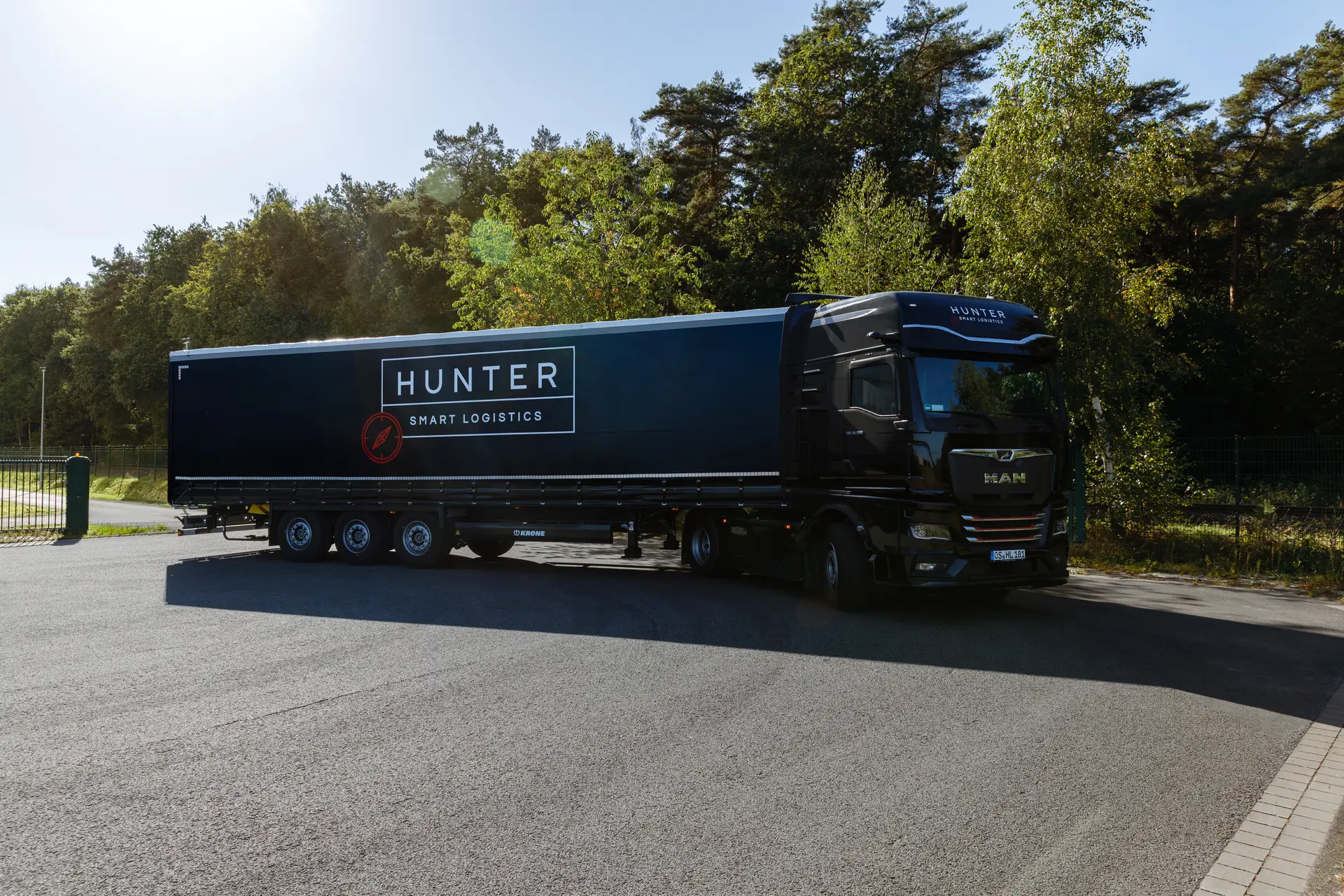 Schwarzer HUNTER Logistics Sattelzug mit MAN-Zugmaschine und Planenauflieger auf dem Firmengelände in Belm bei Osnabrück